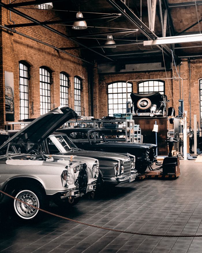 Explore this vintage car workshop in Berlin with classic vehicles in an industrial setting.
